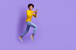 © deagreez - Full body size photo of funky positive young guy running fast speed use gadget texting online sms isolated over violet color background