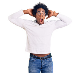 Sticker - Handsome african american man with afro hair wearing casual clothes and glasses crazy and scared with hands on head, afraid and surprised of shock with open mouth