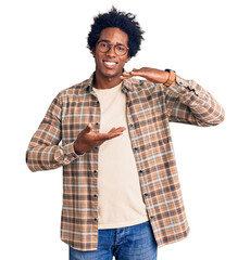 Wall Mural - handsome african american man with afro hair wearing casual clothes and glasses gesturing with hands