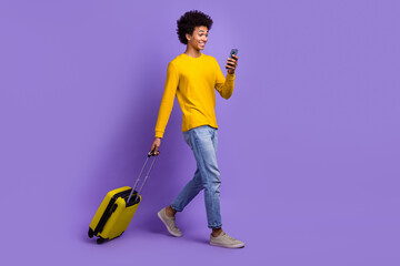 Full body photo of young student guy smartphone chatting with tour operator travel agency with baggage isolated on purple color background