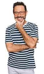 Wall Mural - Middle age man wearing casual clothes and glasses looking confident at the camera smiling with crossed arms and hand raised on chin. thinking positive.