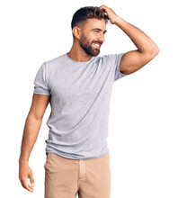 Young hispanic man wearing casual clothes smiling confident touching hair with hand up gesture, posing attractive and fashionable
