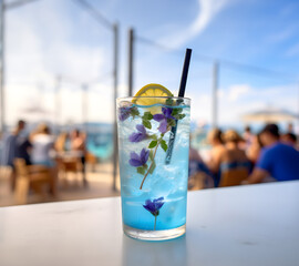 Wall Mural - Blue lagoon cocktail with ice and flowers on a wooden table.