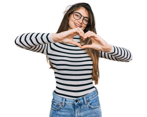 Poster - Young beautiful teen girl wearing casual clothes and glasses smiling in love doing heart symbol shape with hands. romantic concept.