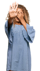 Poster - Beautiful caucasian teenager girl wearing summer dress covering eyes with hands and doing stop gesture with sad and fear expression. embarrassed and negative concept.