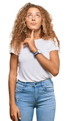 Poster - Beautiful caucasian teenager girl wearing casual white tshirt thinking concentrated about doubt with finger on chin and looking up wondering