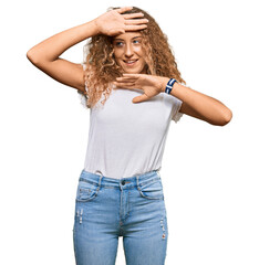 Poster - Beautiful caucasian teenager girl wearing casual white tshirt smiling cheerful playing peek a boo with hands showing face. surprised and exited