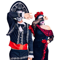 Canvas Print - Young couple wearing mexican day of the dead costume over background covering eyes with arm, looking serious and sad. sightless, hiding and rejection concept