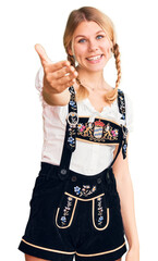 Wall Mural - Young beautiful blonde woman wearing oktoberfest dress smiling friendly offering handshake as greeting and welcoming. successful business.