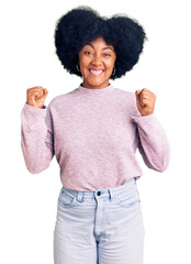 Poster - Young african american girl wearing casual clothes celebrating surprised and amazed for success with arms raised and open eyes. winner concept.