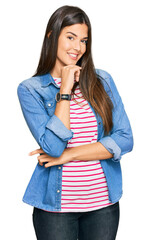 Canvas Print - Young brunette woman wearing casual clothes looking confident at the camera smiling with crossed arms and hand raised on chin. thinking positive.