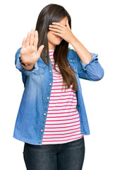 Poster - Young brunette woman wearing casual clothes covering eyes with hands and doing stop gesture with sad and fear expression. embarrassed and negative concept.