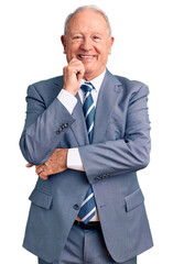 Canvas Print - Senior handsome grey-haired man wearing elegant suit looking confident at the camera with smile with crossed arms and hand raised on chin. thinking positive.