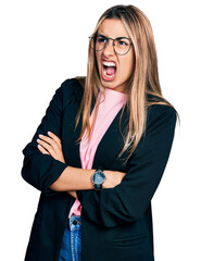 Sticker - Hispanic young woman with arms crossed gesture angry and mad screaming frustrated and furious, shouting with anger. rage and aggressive concept.