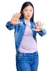 Sticker - Young beautiful chinese woman pregnant expecting baby doing stop gesture with hands palms, angry and frustration expression