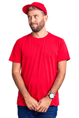 Poster - Young handsome blond man wearing t-shirt and cap smiling looking to the side and staring away thinking.