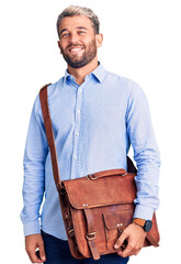 Poster - Young handsome blond man wearing elegant shirt holding briefcase looking positive and happy standing and smiling with a confident smile showing teeth