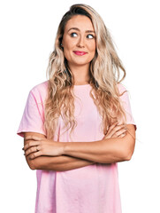 Poster - Young blonde woman with arms crossed gesture smiling looking to the side and staring away thinking.