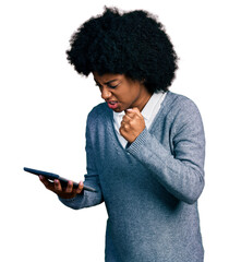 Poster - Young african american woman using touchpad device annoyed and frustrated shouting with anger, yelling crazy with anger and hand raised