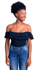 Poster - Young african american woman wearing casual clothes looking away to side with smile on face, natural expression. laughing confident.