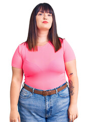 Poster - Young plus size woman wearing casual clothes relaxed with serious expression on face. simple and natural looking at the camera.