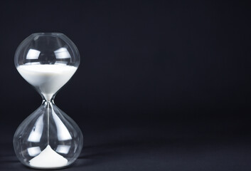 hourglass on black background, running time