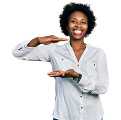 Poster - African american woman with afro hair wearing casual white t shirt gesturing with hands showing big and large size sign, measure symbol. smiling looking at the camera. measuring concept.