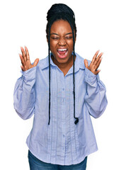 Canvas Print - Young african american woman wearing casual clothes celebrating mad and crazy for success with arms raised and closed eyes screaming excited. winner concept