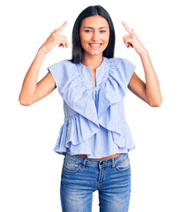 Poster - Young beautiful latin girl wearing casual clothes smiling pointing to head with both hands finger, great idea or thought, good memory