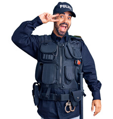 Sticker - Young hispanic man wearing police uniform doing peace symbol with fingers over face, smiling cheerful showing victory