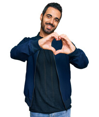 Sticker - Young hispanic man wearing casual clothes smiling in love doing heart symbol shape with hands. romantic concept.