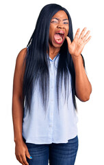 Poster - Young african american woman wearing casual clothes shouting and screaming loud to side with hand on mouth. communication concept.