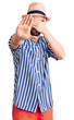 © Krakenimages.com - Young handsome man with beard wearing summer hat and striped shirt covering eyes with hands and doing stop gesture with sad and fear expression. embarrassed and negative concept.
