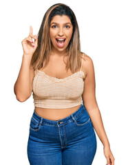 Sticker - Beautiful brunette woman wearing casual clothes pointing finger up with successful idea. exited and happy. number one.