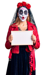 Sticker - Woman wearing day of the dead costume holding empty white chalkboard scared and amazed with open mouth for surprise, disbelief face