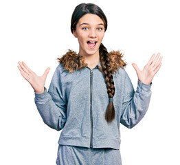 Poster - Young brunette girl with long hair wearing casual sweatshirt celebrating victory with happy smile and winner expression with raised hands