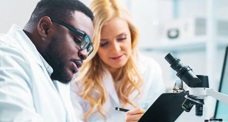 Wall Mural - Team of professional scientists working on a vaccine in a modern scientific research laboratory. Genetic engineer workplace. Future technology, healthcare and science.