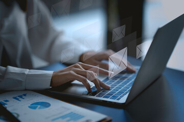 Close-up. Woman hand using computer laptop and sending online message with email icon. Concept of sending e-mails with laptop computer.