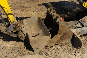 close-up of two excavator buckets at a construction site.