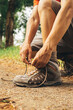 © Djavan Rodriguez - Hiker tying shoe laces in the mountain