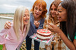 multiracial generational women friends with cake birthday fun