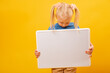 Little blond girl holds white blank board. Copy space, mockup. Preschool education, courses for children