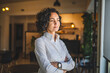 © Miljan Živković - One woman mature caucasian female businesswoman entrepreneur stand at work or home real people copy space wear white shirt curly hair