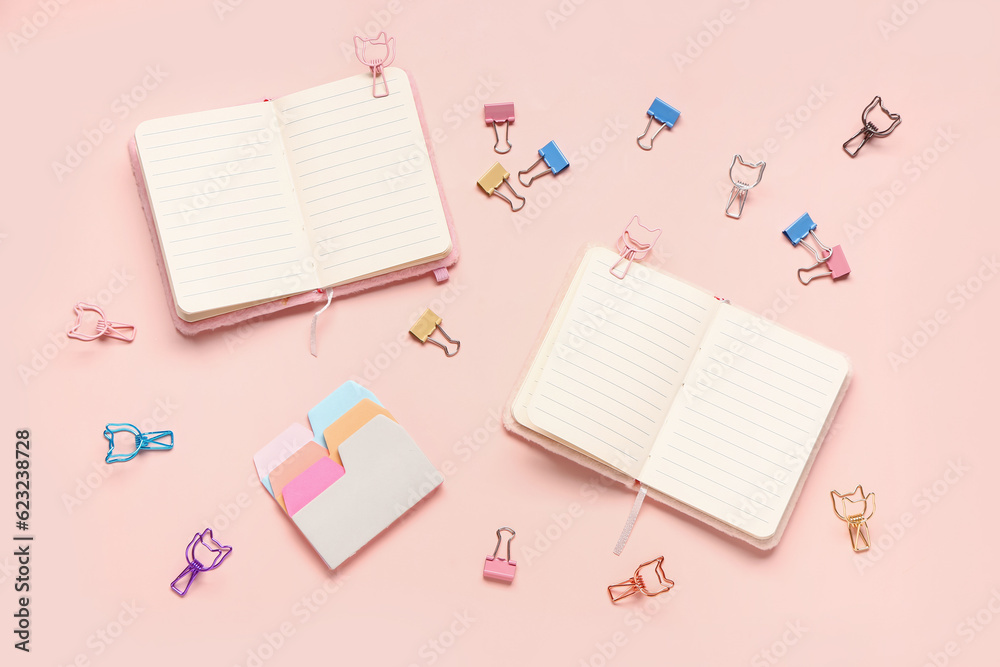 Blank notebooks with binder clips on pink background