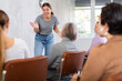 © JackF - Young positive woman speaker in casual clothes gives lecture in front of audience in office