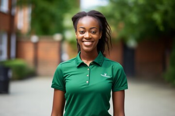 Wall Mural - portrait of young african american woman smiling in green polo shirt