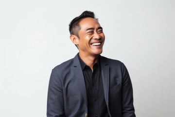 Medium shot portrait photography of a happy Indonesian man in his 40s wearing a chic cardigan against a white background 