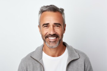 Poster - Portrait of handsome mature man looking at camera and smiling while standing against white background