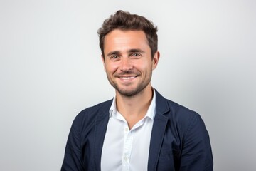 Wall Mural - Portrait of a happy young man smiling at camera on white background