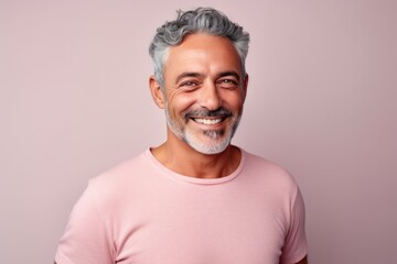Portrait of a smiling middle-aged man with gray hair wearing a pink t-shirt